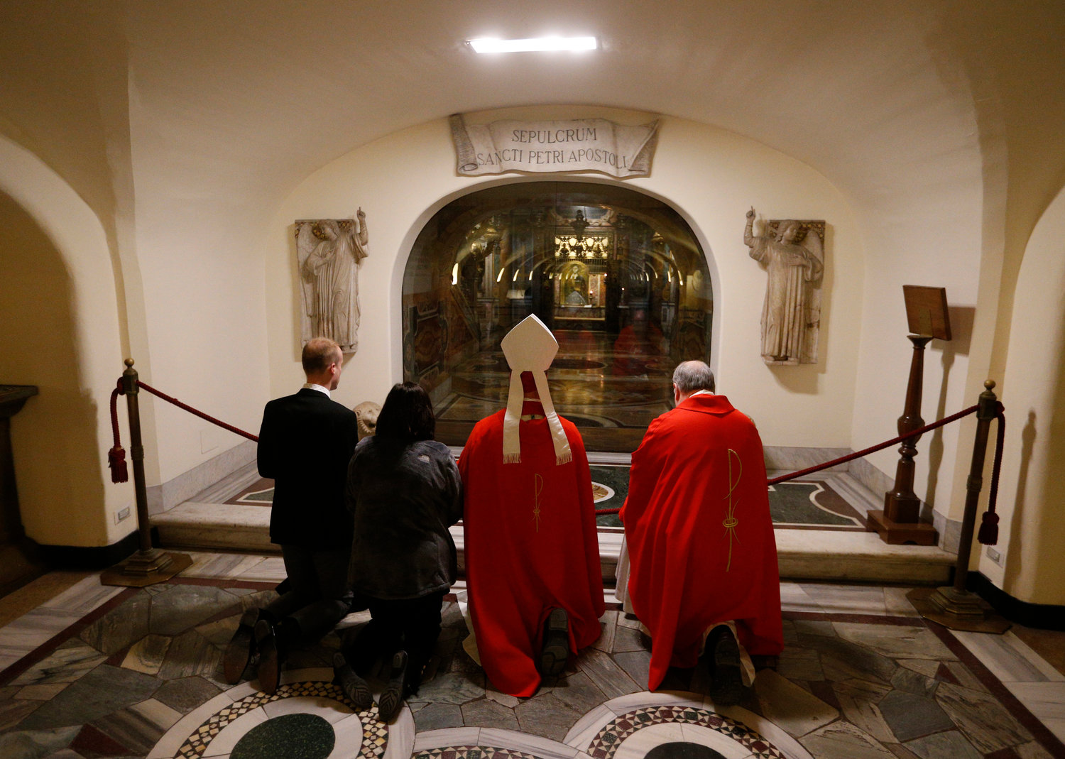 Bishop W. Shawn McKnight of Jefferson City, Mo., center, prays at the tomb of St. Peter after concelebrating Mass with U.S. bishops from Iowa, Kansas, Missouri and Nebraska in the crypt of St. Peter's Basilica at the Vatican Jan. 16, 2020. The bishops were making their "ad limina" visits to the Vatican to report on the status of their dioceses to the pope and Vatican officials.